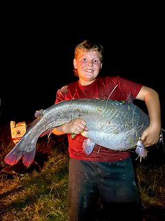 Photo of by holding a large fish at night
