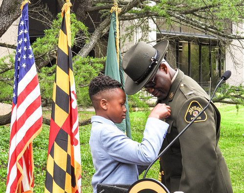 Photo of man in uniform having a badge placed on him by his son.