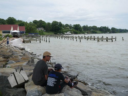 Photo of man and boy fishing from a rocky jetty